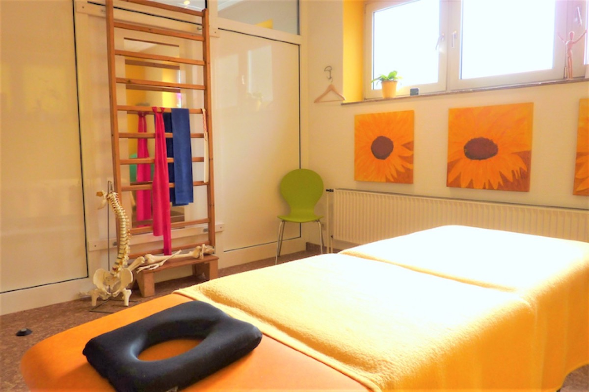 Therapieraum mit Sprossenwand und Behandlungsliege